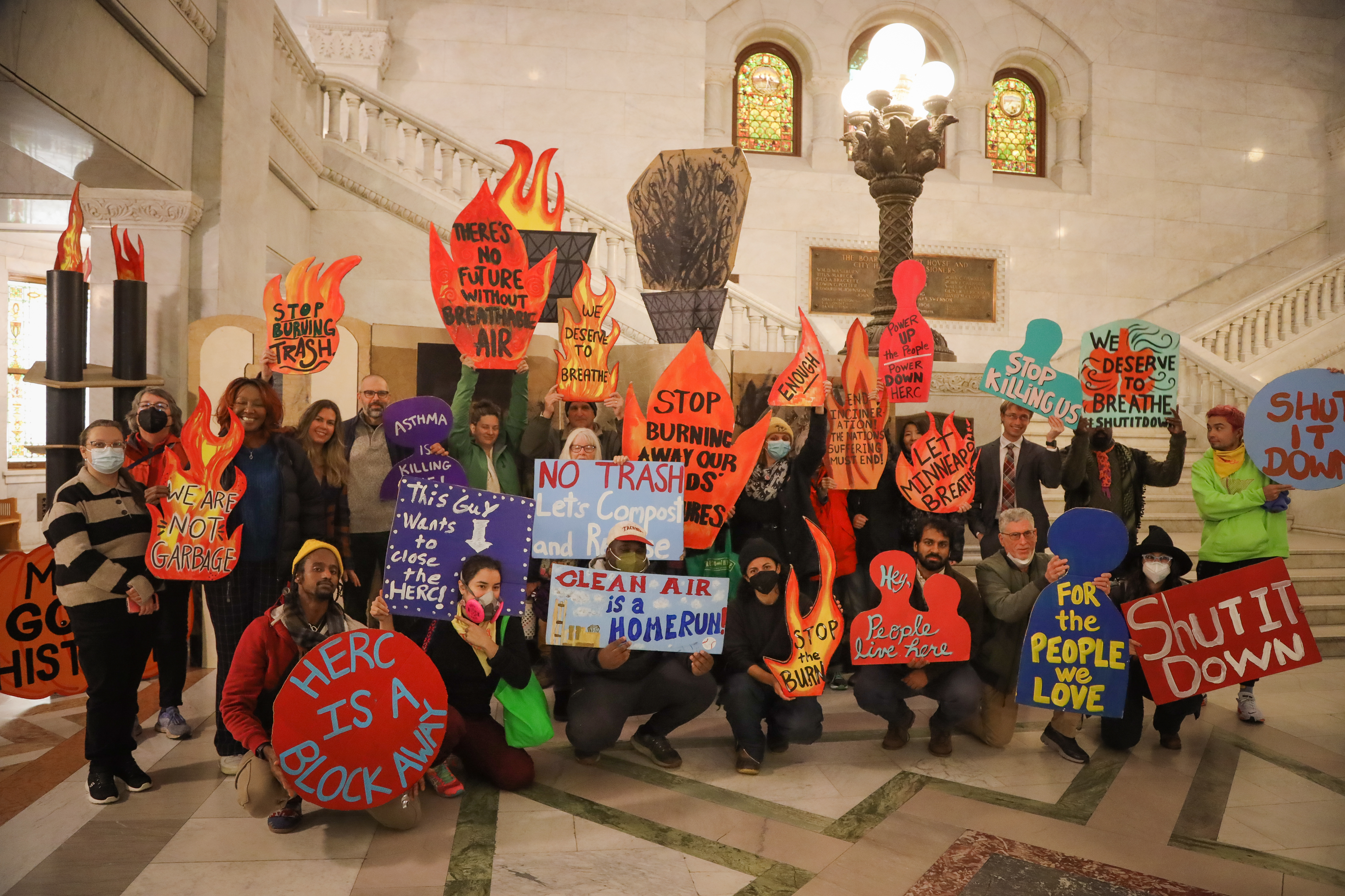 Activists hold signs regarding HERC closure